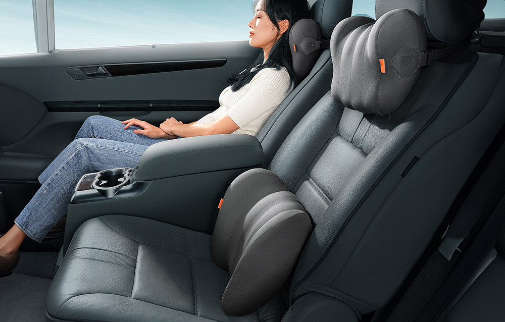 Lumbalni jastuk za automobil BASEUS u upotrebi na vozačevom i suvozačevom sjedištu, dok žena odmara u udobnoj poziciji.