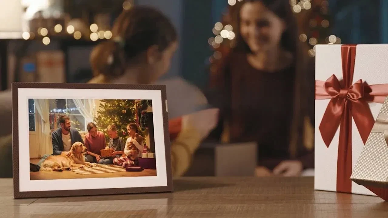 Pametni digitalni foto album ram za slike ARZOPA D10 10.1 inči prikazuje božićnu sliku porodice na stolu.