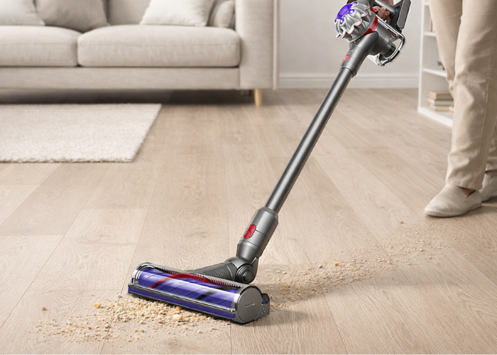 Bežični štapni usisivač čisti mrvice i prašinu sa drvenog poda u dnevnom boravku